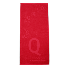 Rotes Badetuch mit mehrfach wiederholtem Quehenberger-Logo in verschiedenen Größen.
